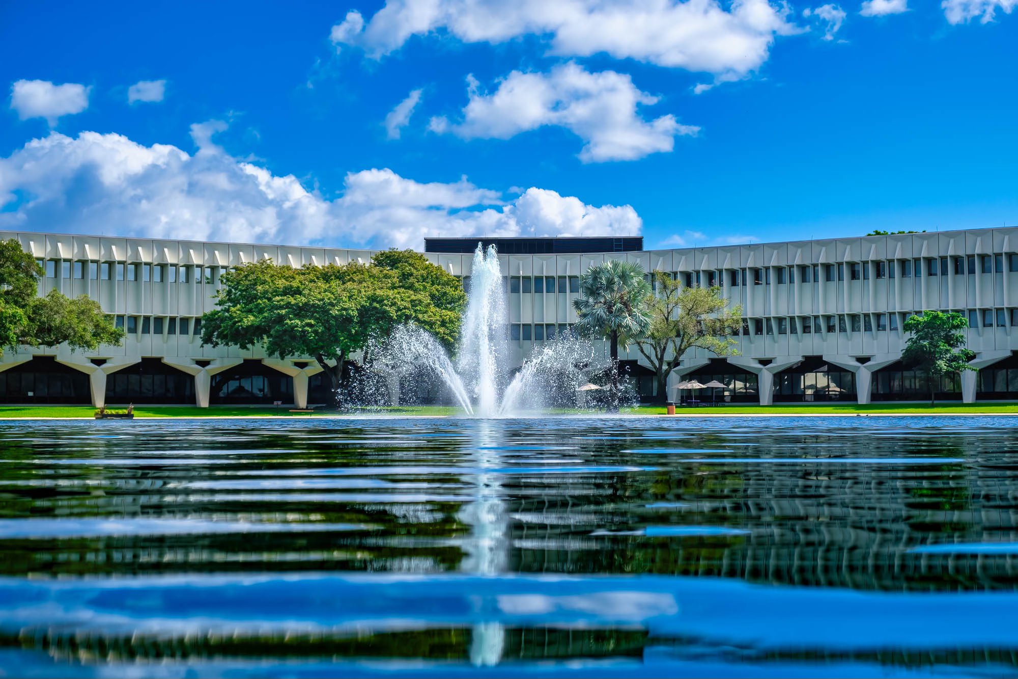 Boca Raton Innovation Campus with fountain and reflecting pool under a bright blue sky